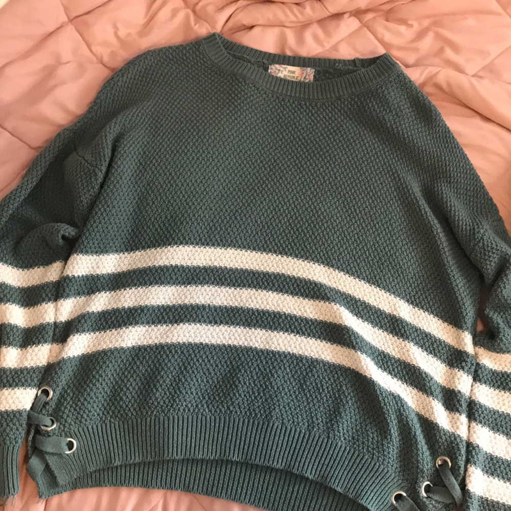 A green knitted sweater with whit strips